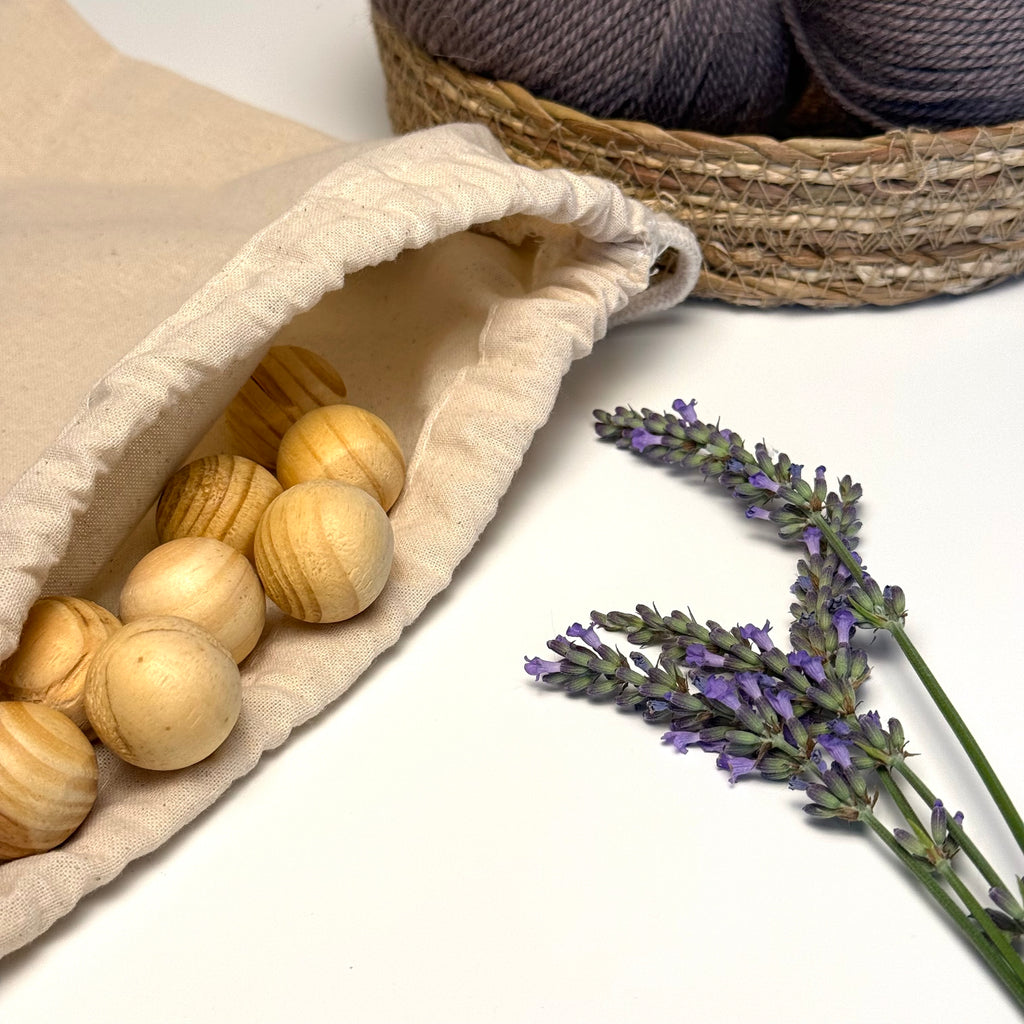 Cedar moth balls in a cotton drawstring bag with lavender next to it and yarn in the background