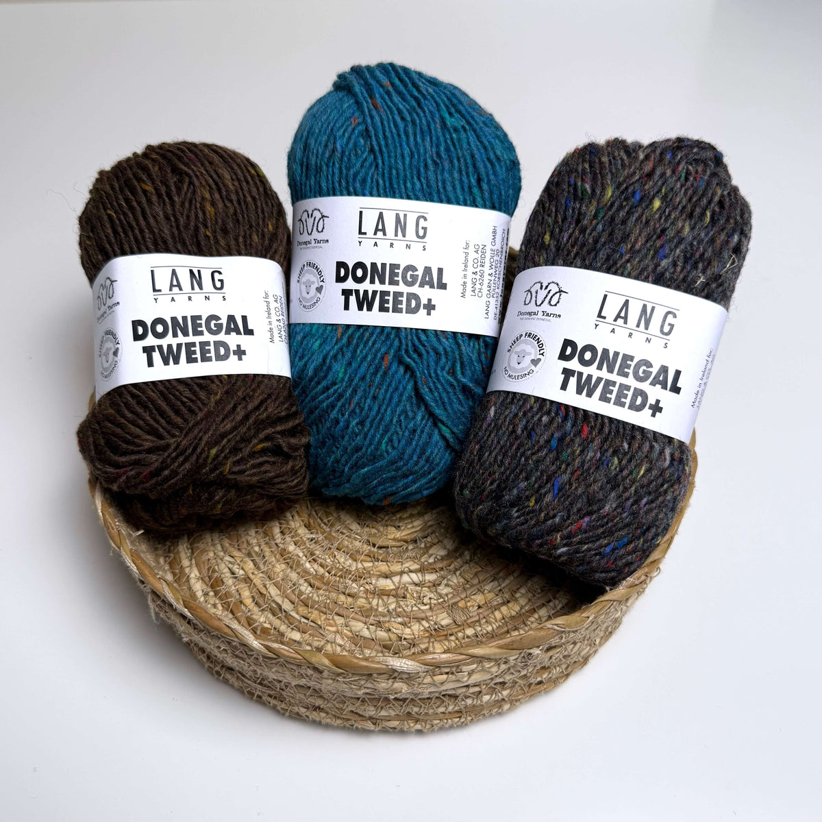 Three balls of Lang Yarns Donegal Tweed Plus in brown, grey and blue